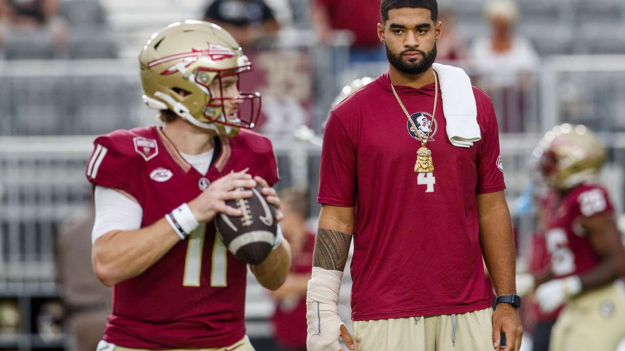 Florida State quarterback DJ Uiagalelei, right, who will not play this game due to a hand injury, watches starting quarterback Brock Glenn (11) warm up before the NCAA college football game against Clemson, Saturday, Oct. 5, 2024, in Tallahassee, Fla.