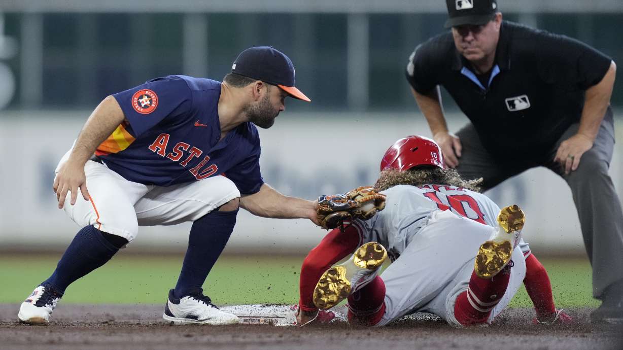 Houston Astros second baseman Jose Altuve, left, catches Los Angeles Angels' Jack López (10) who was trying to steal as umpire Rob Drake, top right, watches for a call during the third inning of a baseball game Sunday, Sept. 22, 2024, in Houston.