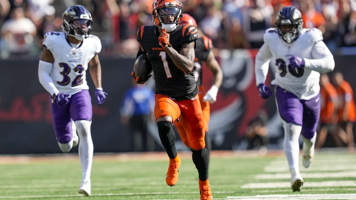 Cincinnati Bengals wide receiver Ja'Marr Chase (1) runs in front of Baltimore Ravens safety Marcus Williams (32) and running back Owen Wright (36) for a long touchdown after making a catch during the second half of an NFL football game, Sunday, Oct. 6, 2024, in Cincinnati.