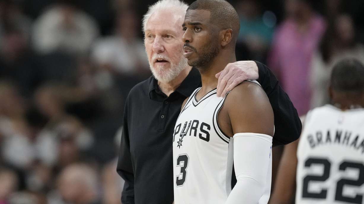 San Antonio Spurs head coach Gregg Popovich, left, talks with guard Chris Paul (3) during the first half of a preseason NBA basketball game against the Orlando Magic in San Antonio, Wednesday, Oct. 9, 2024.