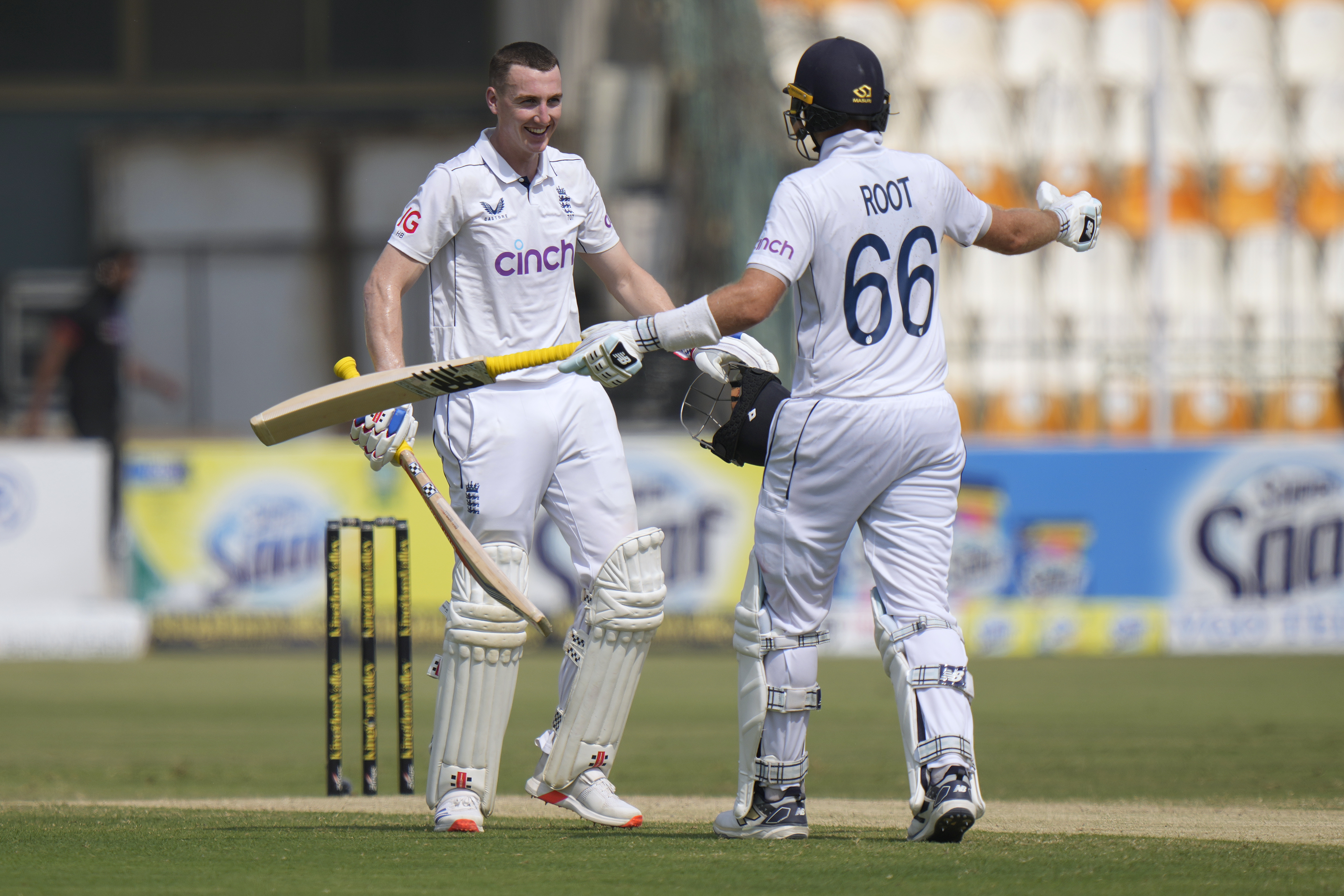 England's Harry Brook, centre, celebrates with Joe Root after scoring double century during the fourth day of the first test cricket match between Pakistan and England, in Multan, Pakistan, Thursday, Oct. 10, 2024.