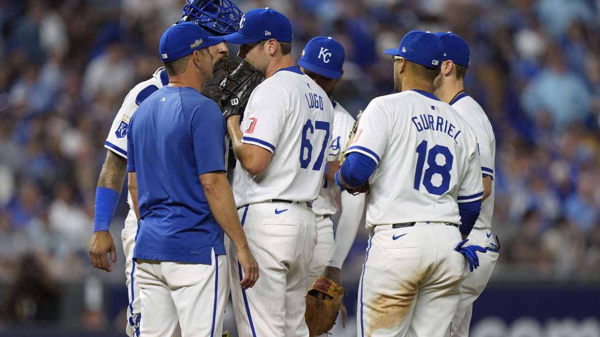 Kansas City Royals starting pitcher Seth Lugo (67) talks with Royals pitching coach Brian Sweeney, left, during the fifth inning in Game 3 of an American League Division baseball playoff series against the New York Yankees Wednesday, Oct. 9, 2024, in Kansas City, Mo.