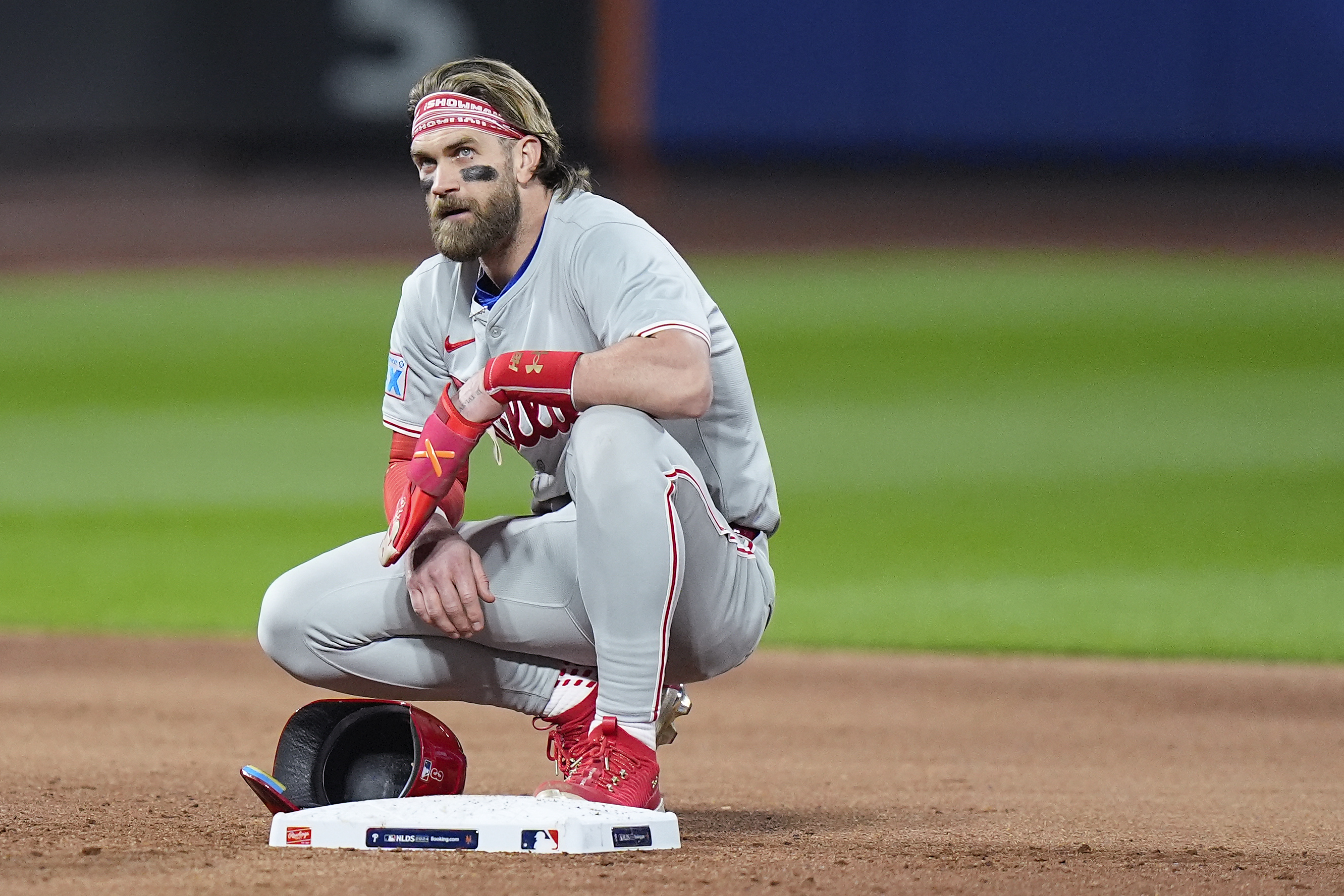 Philadelphia Phillies first baseman Bryce Harper (3) takes a break during a pitching change by the New York Mets during the sixth inning of Game 4 of the National League baseball playoff series, Wednesday, Oct. 9, 2024, in New York.