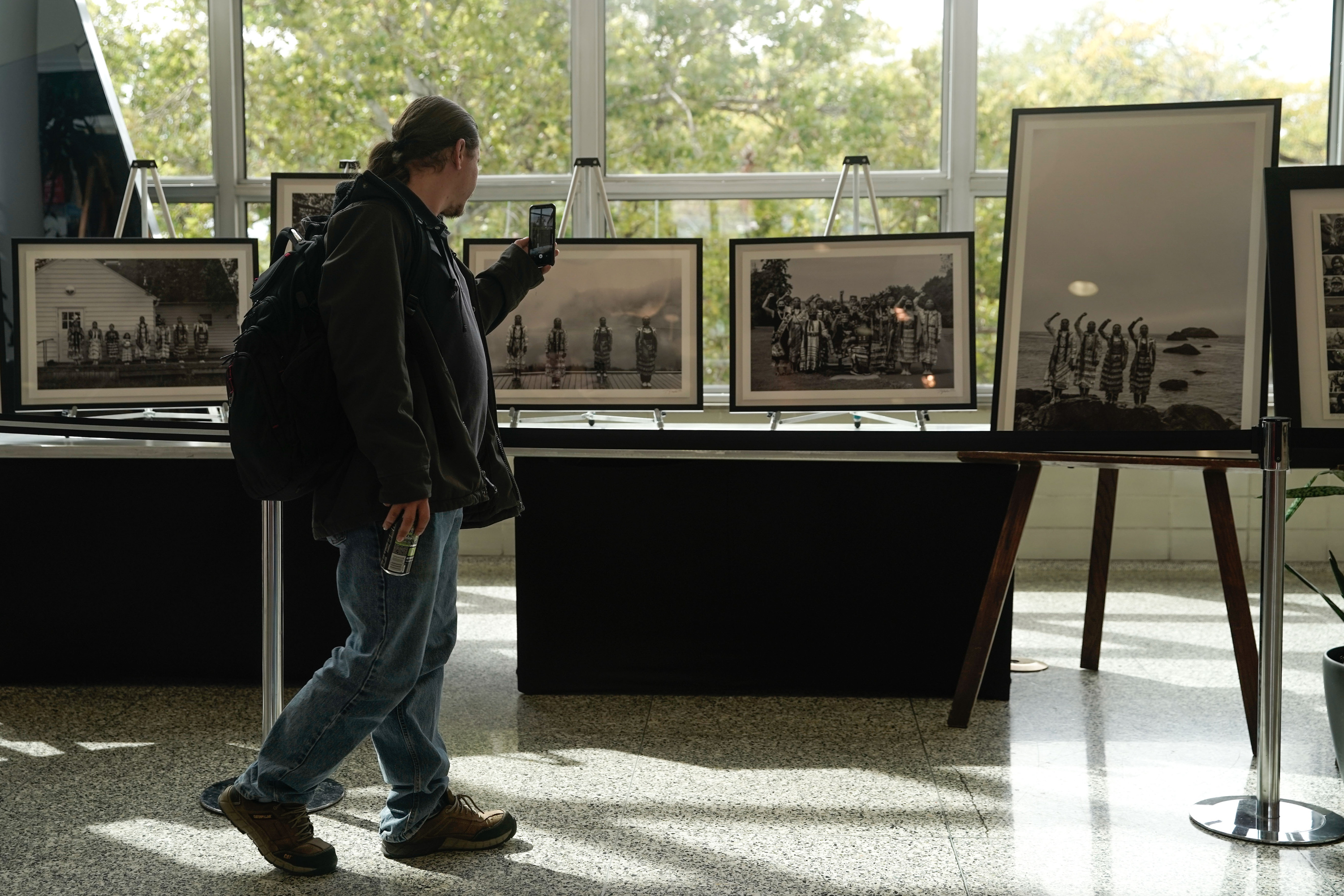 A visitor passes by photographs recognizing Indigenous Peoples Day at the University of Utah's A. Ray Olpin Union on Oct. 11, 2021. The photos are by Matika Wilbur and Vicki Eagle, of Native and Indigenous People in the United States.