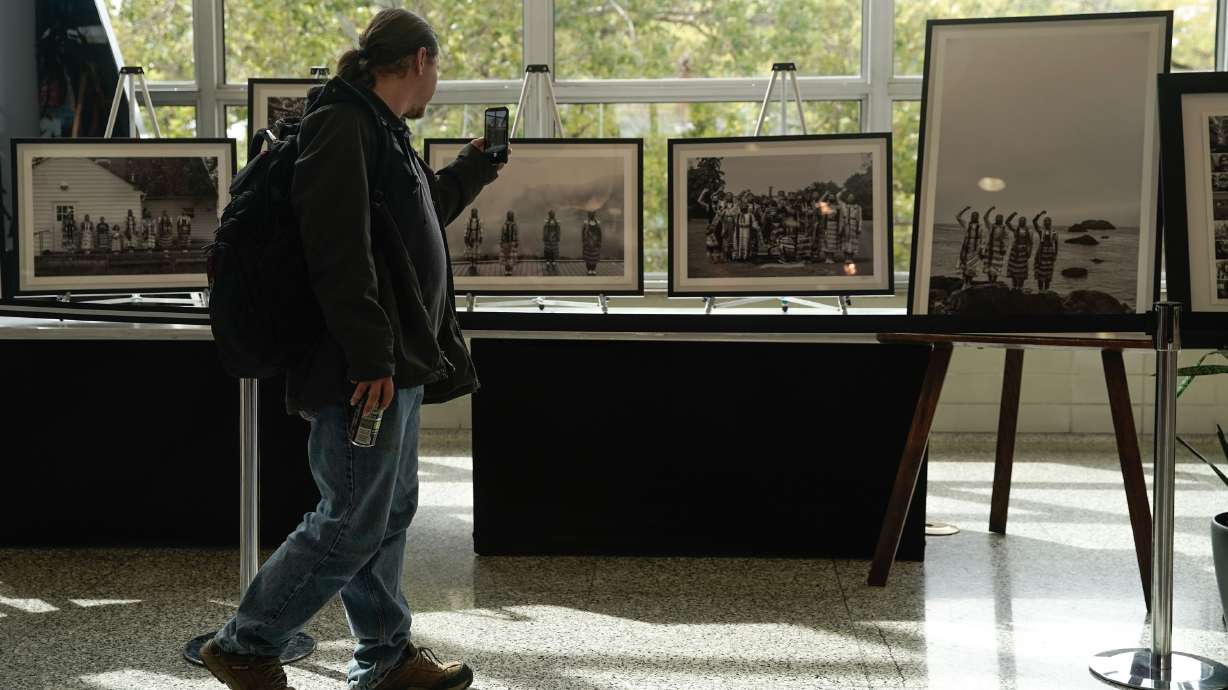 A visitor passes by photographs recognizing Indigenous Peoples Day at the University of Utah's A. Ray Olpin Union on Oct. 11, 2021. The photos are by Matika Wilbur and Vicki Eagle, of Native and Indigenous People in the United States.