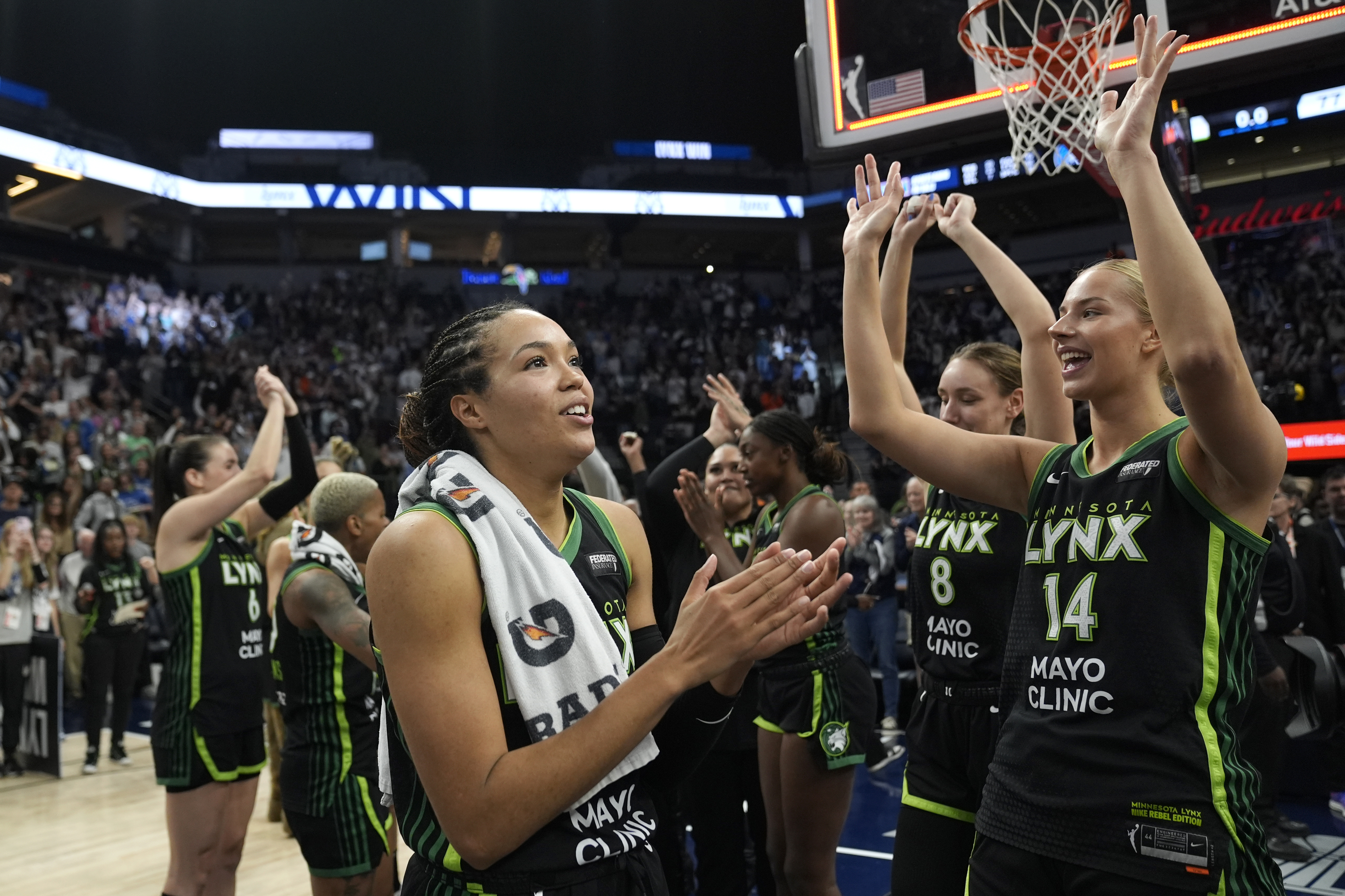 Minnesota Lynx forward Napheesa Collier, center, celebrates with teammates after the 88-77 win against the Connecticut Sun of Game 5 of a WNBA basketball semifinals, Tuesday, Oct. 8, 2024, in Minneapolis.