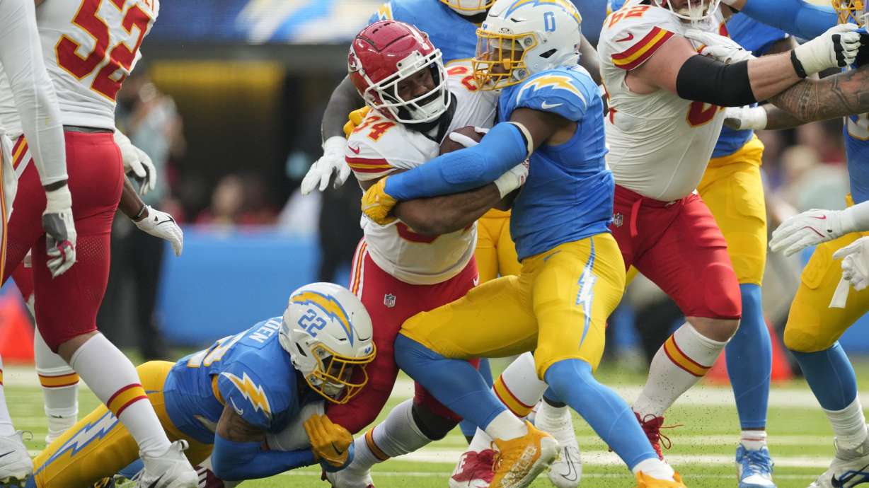 Kansas City Chiefs running back Samaje Perine (34) is stopped by Los Angeles Chargers defensive back Elijah Molden (22) and linebacker Daiyan Henley (0) during the first half of an NFL football game Sunday, Sept. 29, 2024, in Inglewood, Calif.
