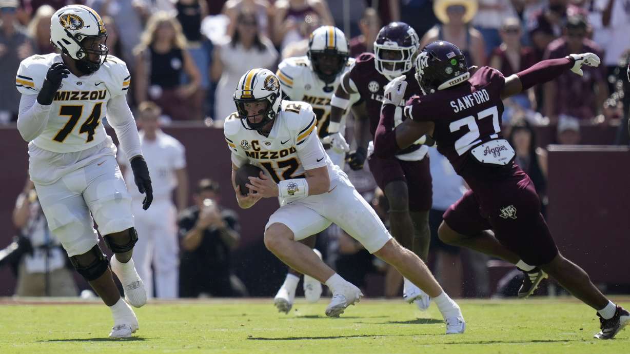 Missouri quarterback Brady Cook (12) tries to escape Texas A&M linebacker Daymion Sanford (27) during the first half of an NCAA college football game Saturday, Oct. 5, 2024, in College Station, Texas.
