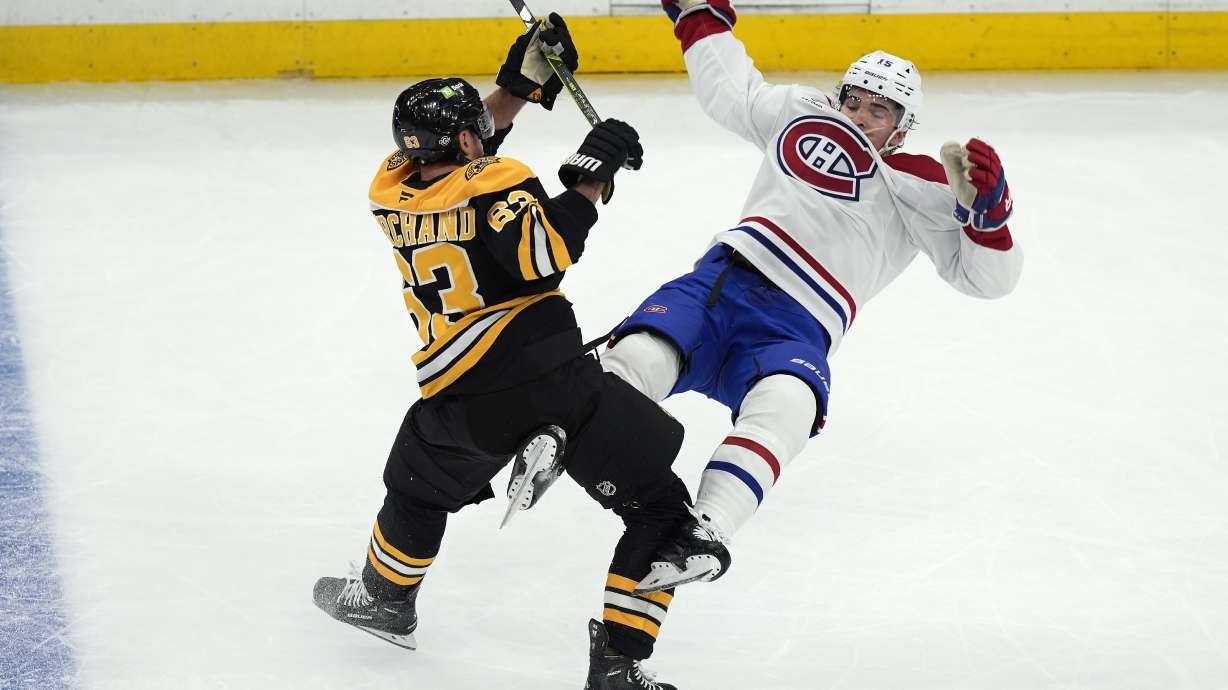 Boston Bruins' Brad Marchand (63) checks Montreal Canadiens' Alex Newhook (15) during the first period of an NHL hockey game, Thursday, Oct. 10, 2024, in Boston.