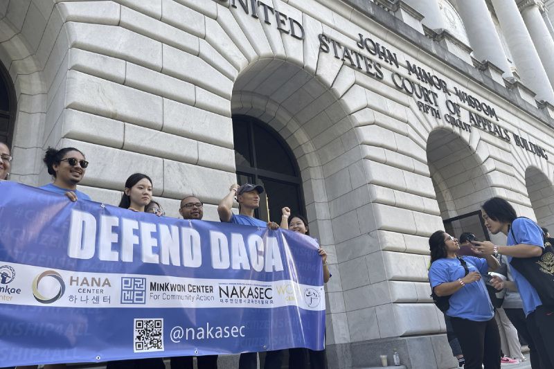 Demonstrators supporting Biden Administration efforts to protect immigrants brought to the U.S. illegally when they were children hold signs in front of the federal appeals court in New Orleans on Thursday.