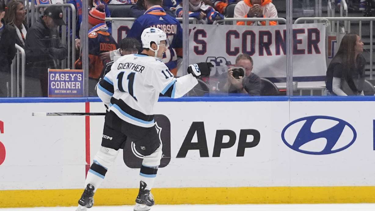 Utah Hockey Club's Dylan Guenther (11) celebrates after scoring the game winning goal during the overtime period of an NHL hockey game against the New York Islanders Thursday, Oct. 10, 2024, in Elmont, N.Y.