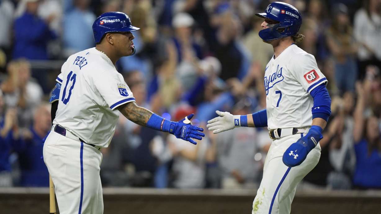 Kansas City Royals' Bobby Witt Jr. (7) is congratulated by teammate Salvador Perez (13) after scoring during the sixth inning in Game 4 of an American League Division baseball playoff series against the New York Yankees Thursday, Oct. 10, 2024, in Kansas City, Mo.
