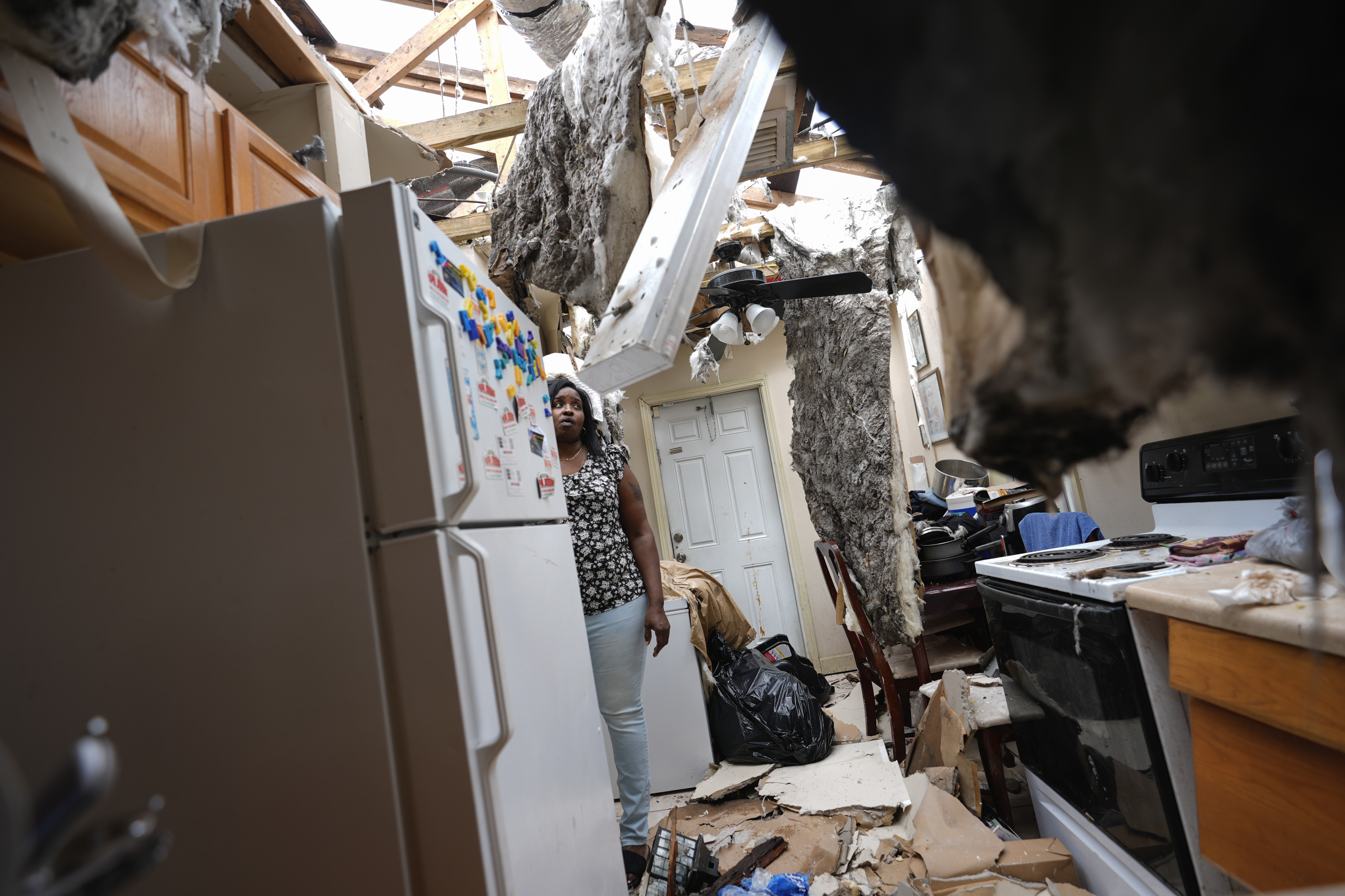 Natasha Ducre surveys the kitchen of her devastated home, which lost most of its roof during the passage of Hurricane Milton, in Palmetto, Fla., Thursday. Ducre, her husband, three children, and two grandkids rode out the storm in a government shelter and returned to find their home unlivable and much of their furniture and belongings destroyed by rainwater.