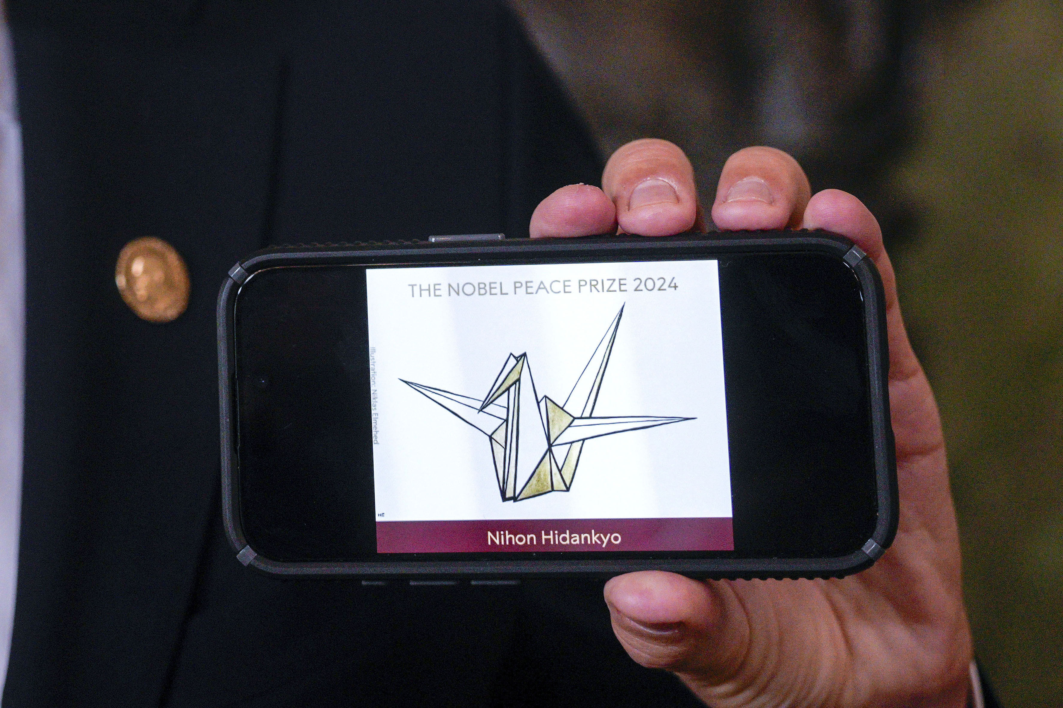 The head of the Nobel Committee, Jorgen Watne Frydnes, shows the logo of the Japanese organization Nihon Hidankyo, the winner of the Nobel Peace Prize for 2024, at the Nobel Institute in Oslo, Norway, Friday.