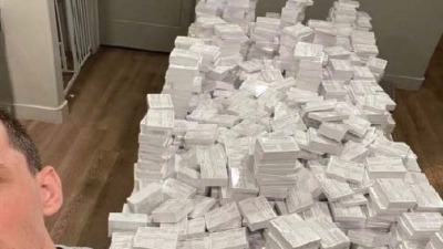 Nicholas Frank Sciotto poses next to piles of fake COVID-19 vaccination cards in 2021. The Salt Lake man was sentenced to a year in prison Thursday for selling over 120,000 of them during the pandemic.