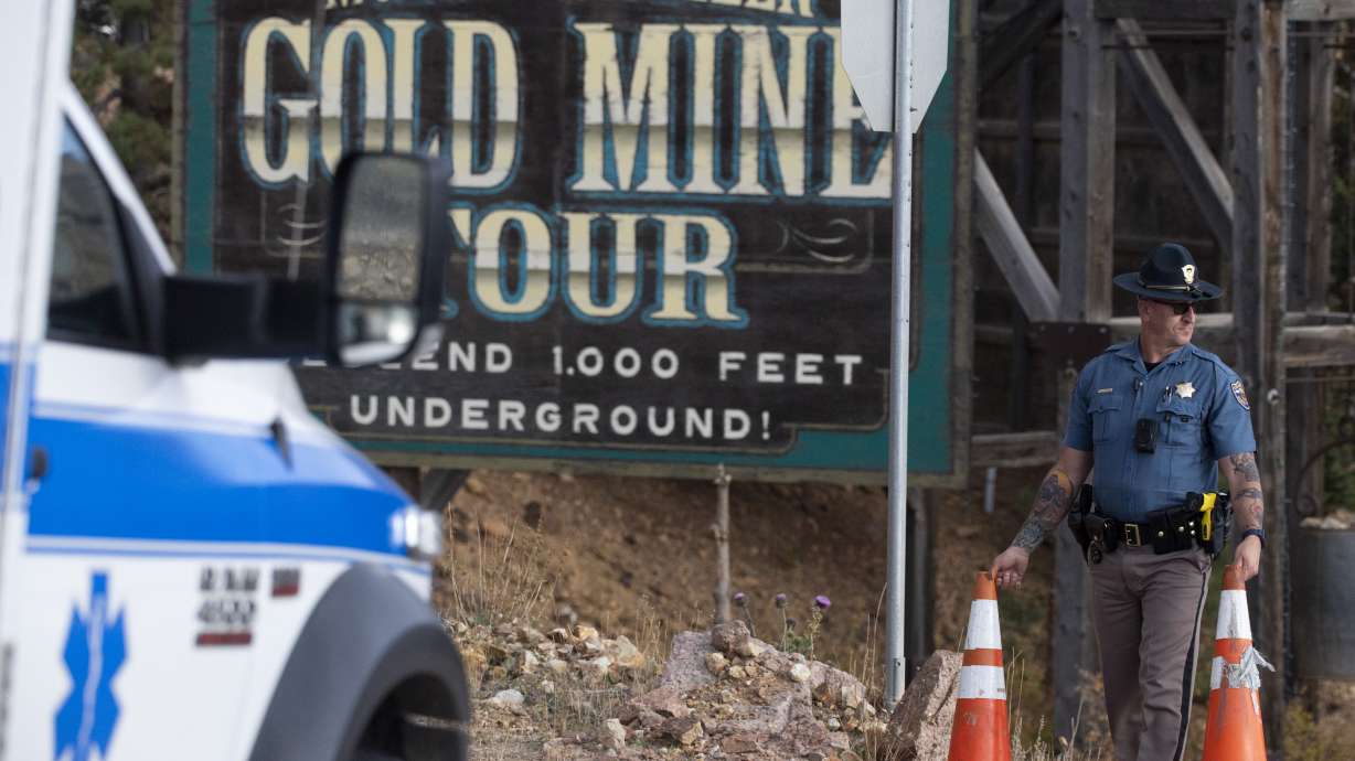 A police officer moves a barrier for an emergency vehicle Thursday, at Mollie Kathleen Gold Mine in Cripple Creek, Colo.