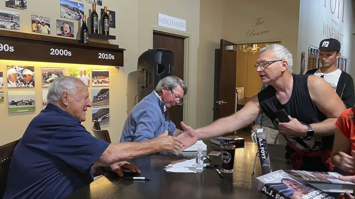 Four time Indianapolis 500 winner A.J. Foyt, left, shakes hands with a fan during a book-signing, Thursday night, Oct. 10, 2024, at the Foyt Wine Vault in Speedway, Ind. Foyt and author Art Garner, center rear, were in town to promote the release of Garner's new biography "A.J. Foyt -- Volume 1: Survivor, Champion, Legend." A second volume has a tentative release date of May 2026.
