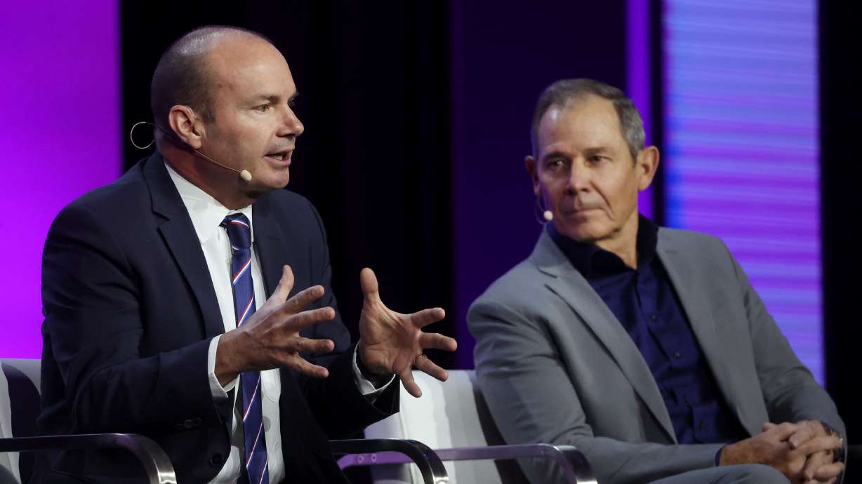 Sen. Mike Lee, R-Utah, and Rep. John Curtis, R-Utah, speak at the Salt Palace Convention Center in Salt Lake City on Friday. The two told a room of cryptocurrency developers on Friday that digital money represents a revolution in financial freedom.