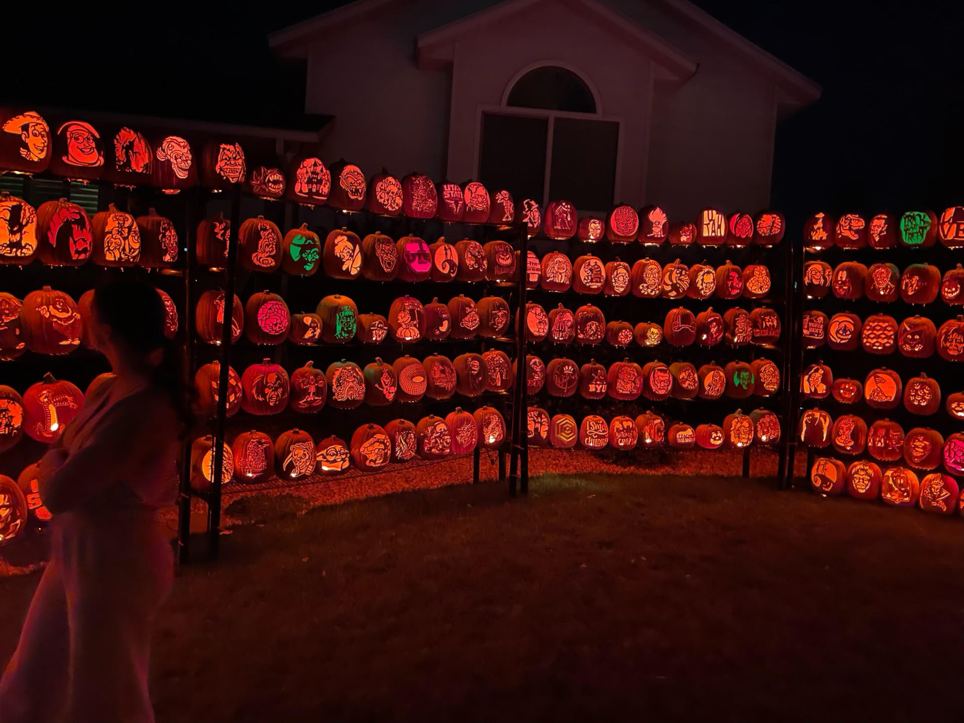 A visitor takes a look at the carved pumpkins at Ken's Pumpkin Patch in Farmington. Visiting the display is free and open to the public.