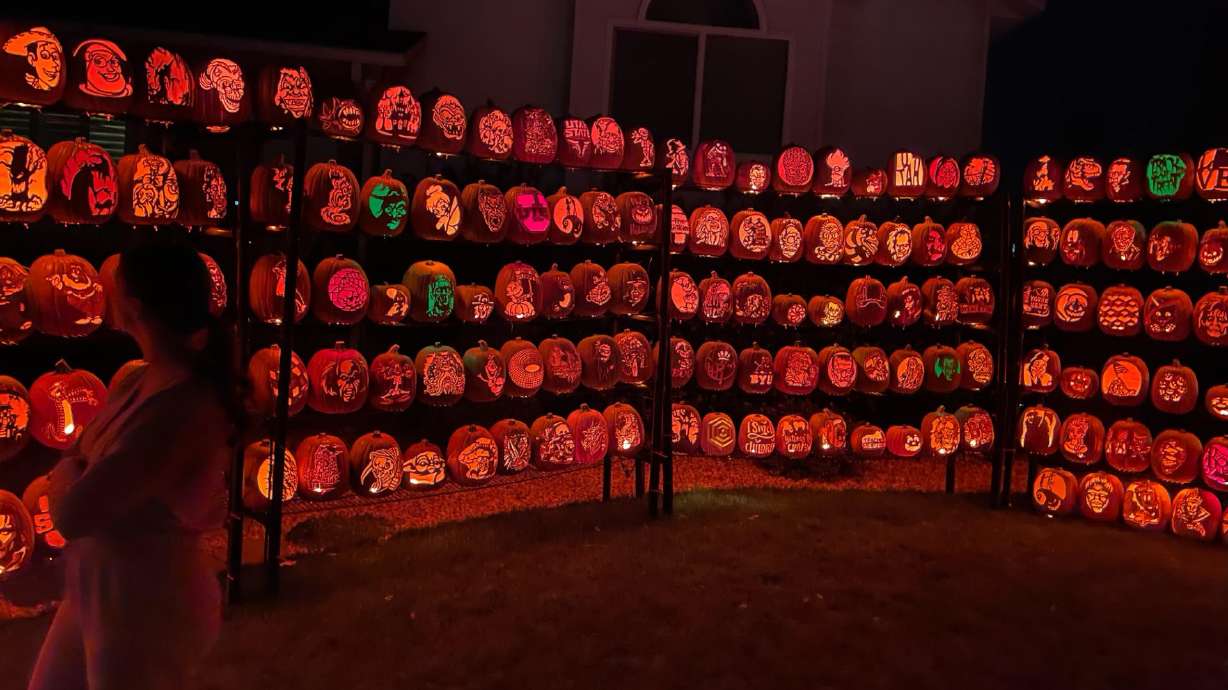 A visitor takes a look at the carved pumpkins at Ken's Pumpkin Patch in Farmington. Visiting the display is free and open to the public.
