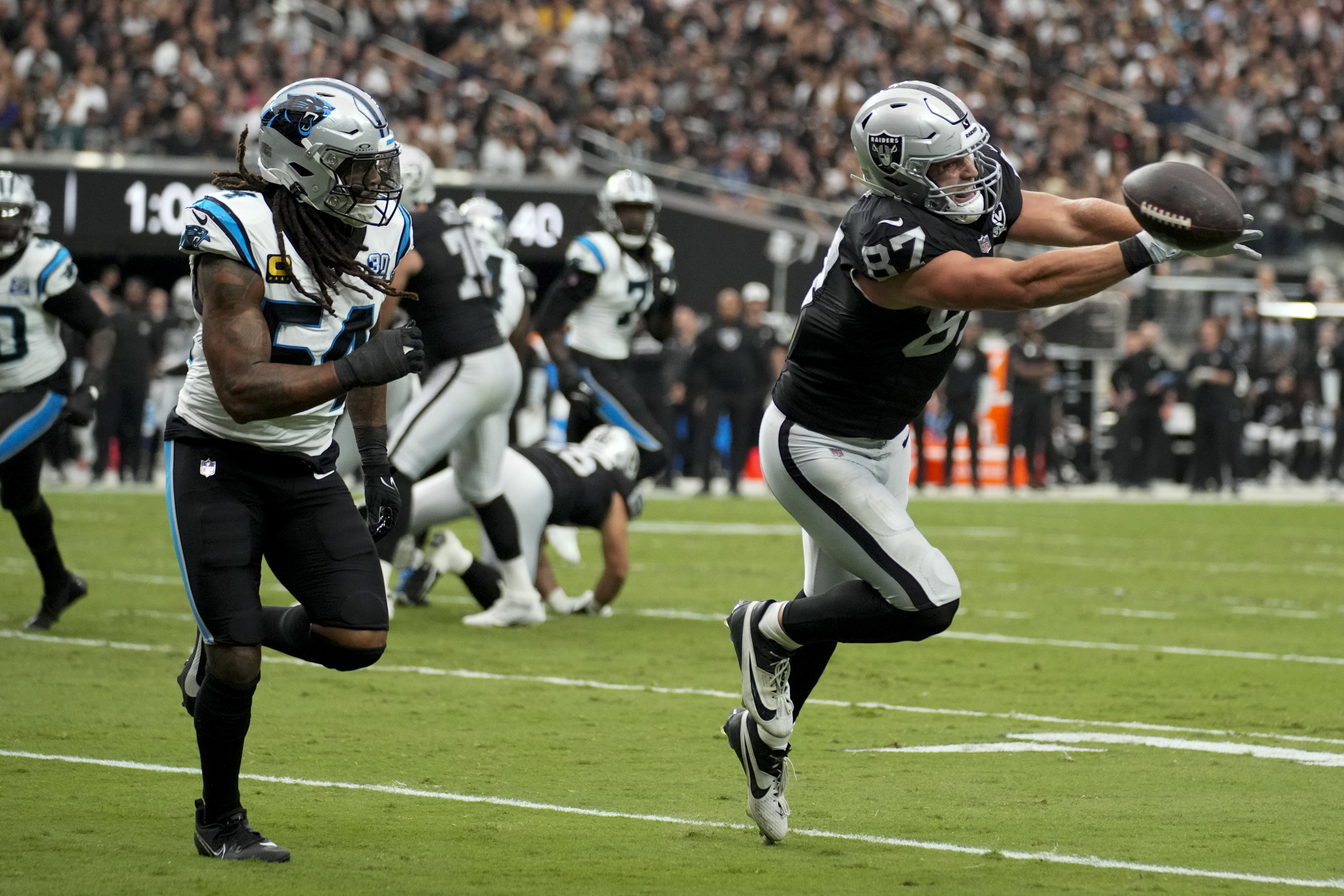 Las Vegas Raiders tight end Michael Mayer missed a pass as Carolina Panthers linebacker Shaq Thompson looks on during the first half of an NFL football game, Sunday, Sept. 22, 2024, in Las Vegas.