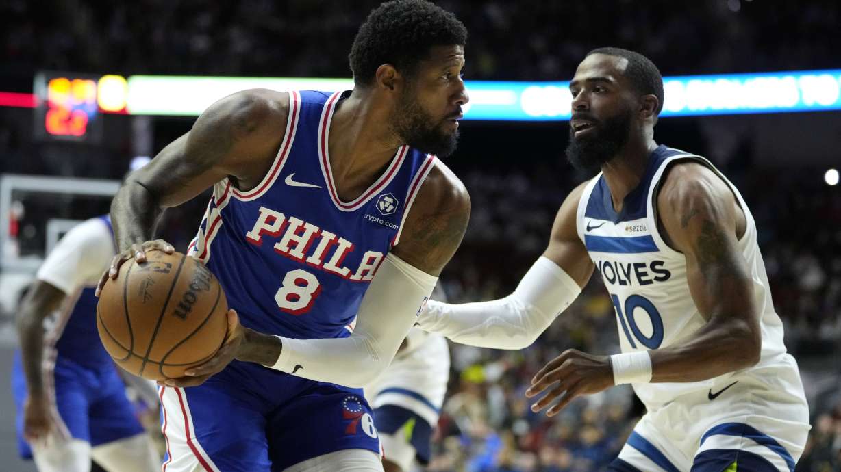 Philadelphia 76ers forward Paul George (8) looks to drive around Minnesota Timberwolves guard Mike Conley (10) during the first half of an NBA preseason basketball game, Friday, Oct. 11, 2024, in Des Moines, Iowa.