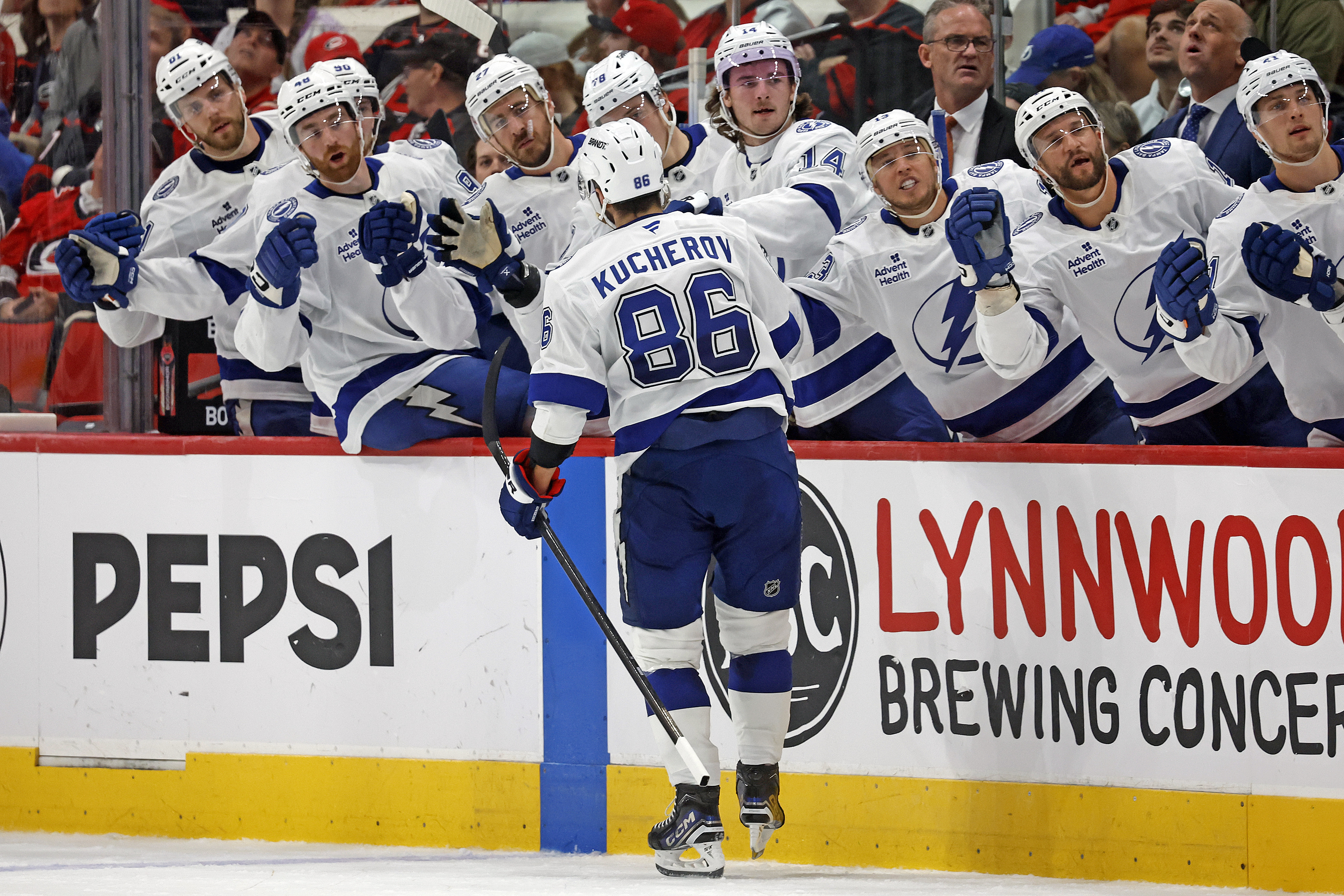 Tampa Bay Lightning's Nikita Kucherov (86) celebrates after his goal along the fence during the third period of an NHL hockey game against the Carolina Hurricanes in Raleigh, N.C., Friday, Oct. 11, 2024.