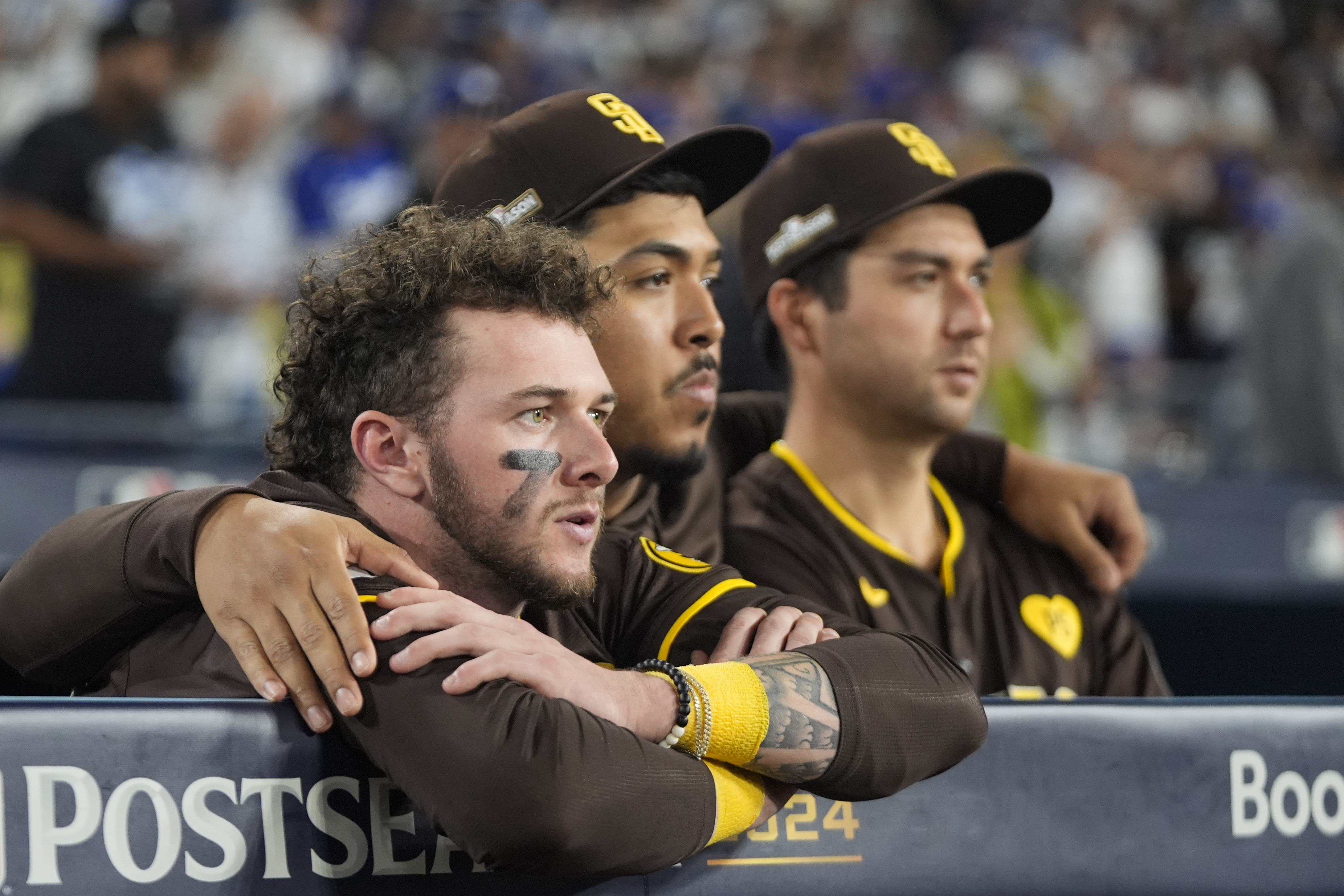 San Diego Padres center fielder Jackson Merrill, left, looks on alongside relief pitcher Jeremiah Estrada, center, and catcher Kyle Higashioka after a loss to the Los Angeles Dodgers in Game 5 of a baseball NL Division Series Friday, Oct. 11, 2024, in Los Angeles.