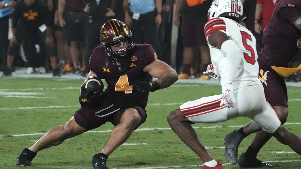 Arizona State running back Cam Skattebo avoids Utah cornerback Zemaiah Vaughn (5) in the first half during an NCAA college football game, Friday, Oct. 11, 2024, in Tempe, Ariz.