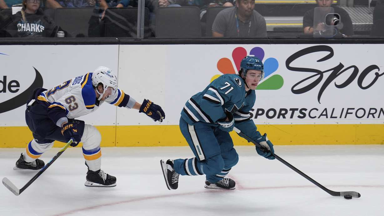 St. Louis Blues left wing Jake Neighbours, left, chases after San Jose Sharks center Macklin Celebrini, right, during the first period of an NHL hockey game Thursday, Oct. 10, 2024, in San Jose, Calif.