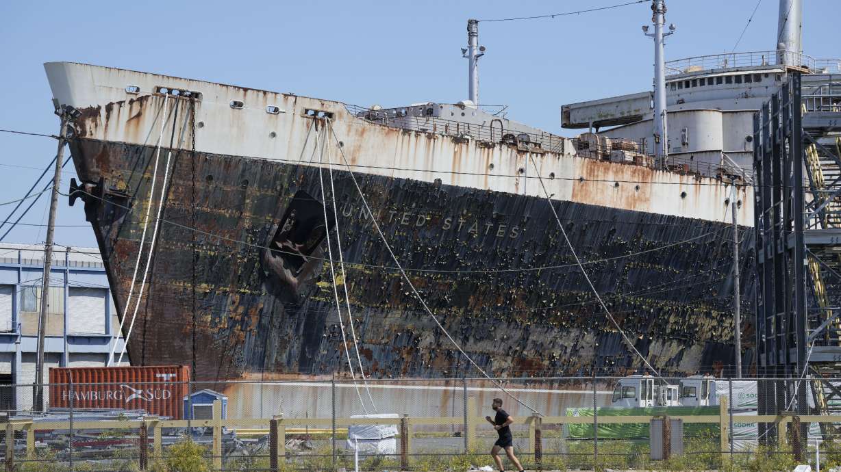 A person runs past the S.S. United States moored on the Delaware River in Philadelphia, Sept. 4.
