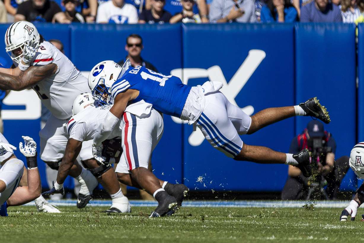 BYU linebacker Isaiah Glasker (16) downs Arizona running back Quali Conley (7) during a game at LaVell Edwards Stadium in Provo on Saturday, Oct. 12, 2024.