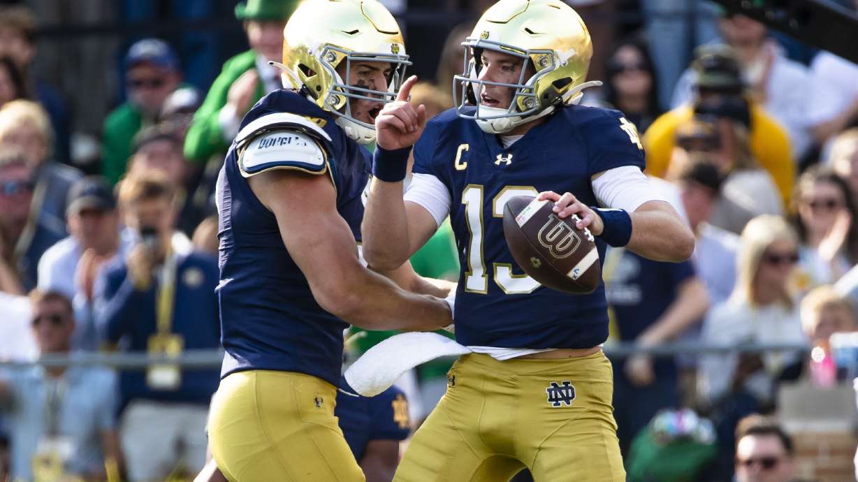 Notre Dame quarterback Riley Leonard, right, celebrates after scoring a touchdown with tight end Eli Raridon, left, during an NCAA college football game against Stanford, Saturday, Oct. 12, 2024, in South Bend, Ind.