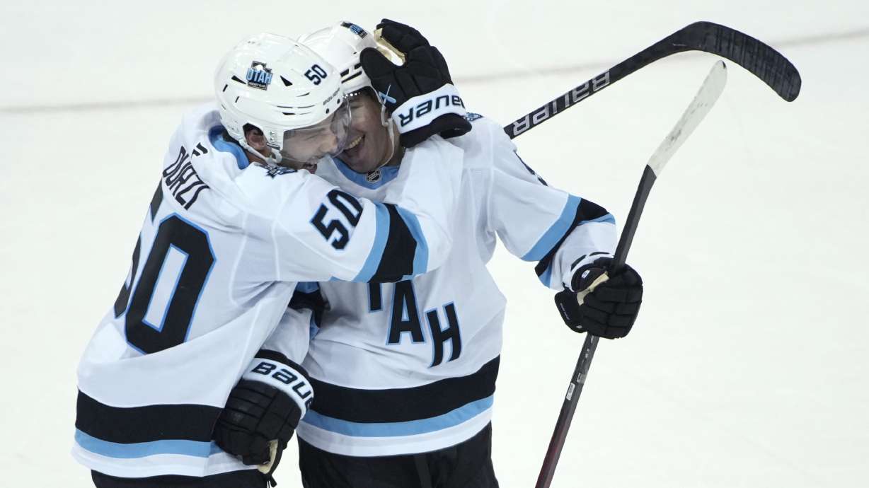 Utah Hockey Club's Sean Durzi, left, and Clayton Keller, right, react after Keller scored the winning goal during overtime of an NHL hockey game against the New York Rangers, Saturday, Oct. 12, 2024, in New York.