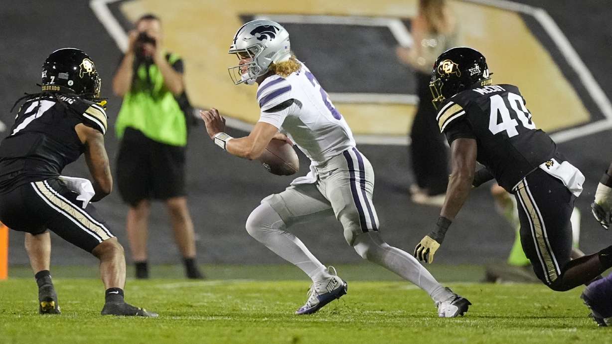 Kansas State quarterback Avery Johnson, center, is pursued by Colorado safety Cam'Ron Silmon-Craig, left, and defensive end Taje McCoy in the first half of an NCAA college football game Saturday, Oct. 12, 2024, in Boulder, Colo.