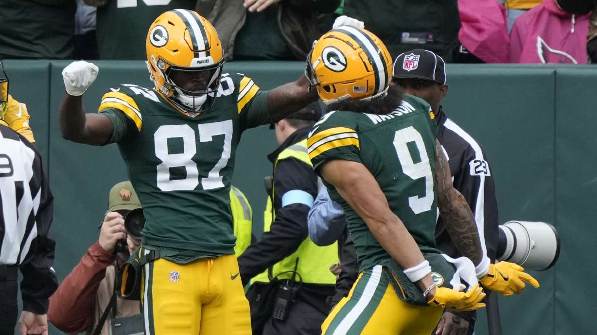 Green Bay Packers wide receiver Romeo Doubs (87) celebrates his 20-yard reception for a touchdown with teammate wide receiver Christian Watson during the second half of an NFL football game against the Arizona Cardinals, Sunday, Oct. 13, 2024, in Green Bay.
