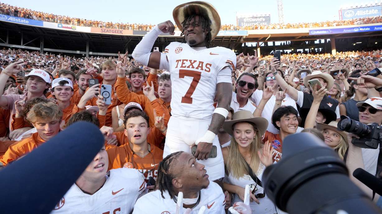 Texas defensive back Jahdae Barron (7) wears the Golden Hat Trophy as he celebrates the team's win against Oklahoma with fans after an NCAA college football game in Dallas, Saturday, Oct. 12, 2024.