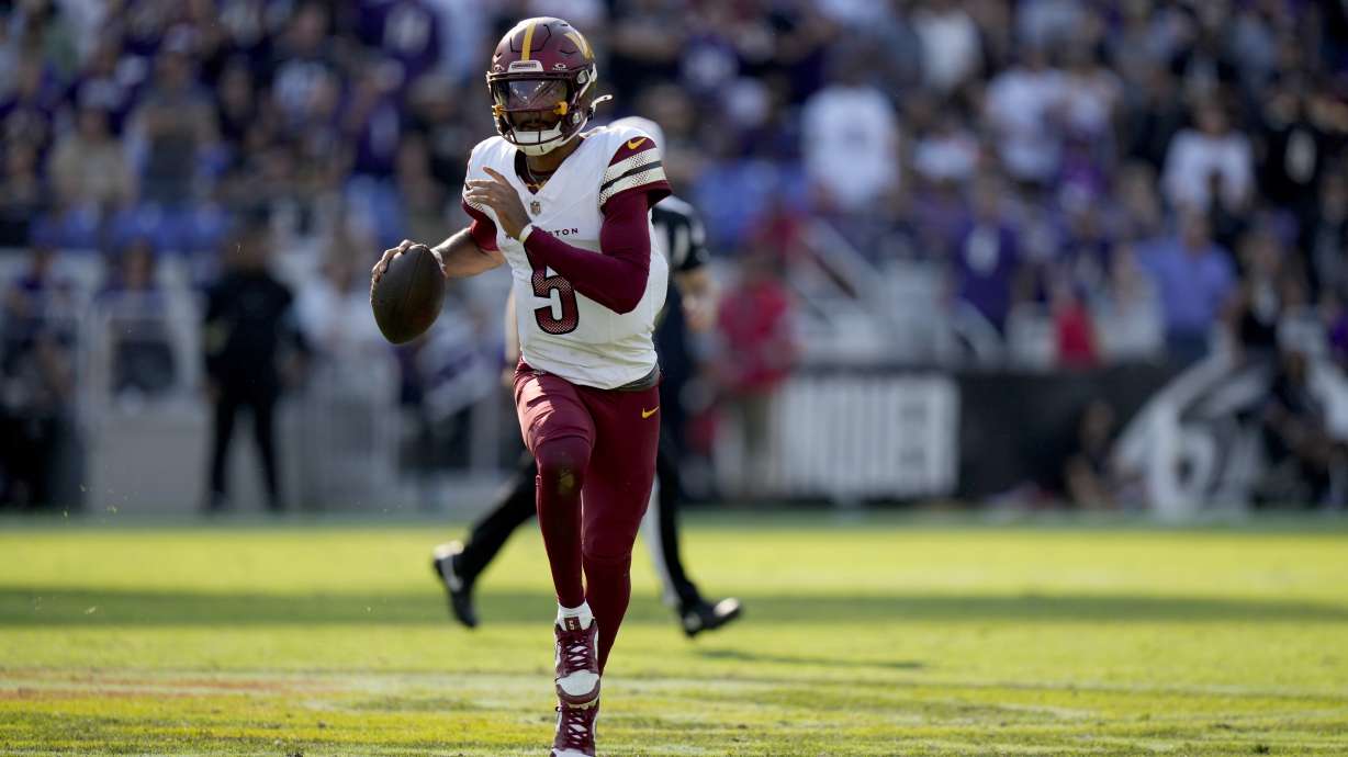 Washington Commanders quarterback Jayden Daniels scrambles during the second half of an NFL football game against the Baltimore Ravens Sunday, Oct. 13, 2024, in Baltimore.