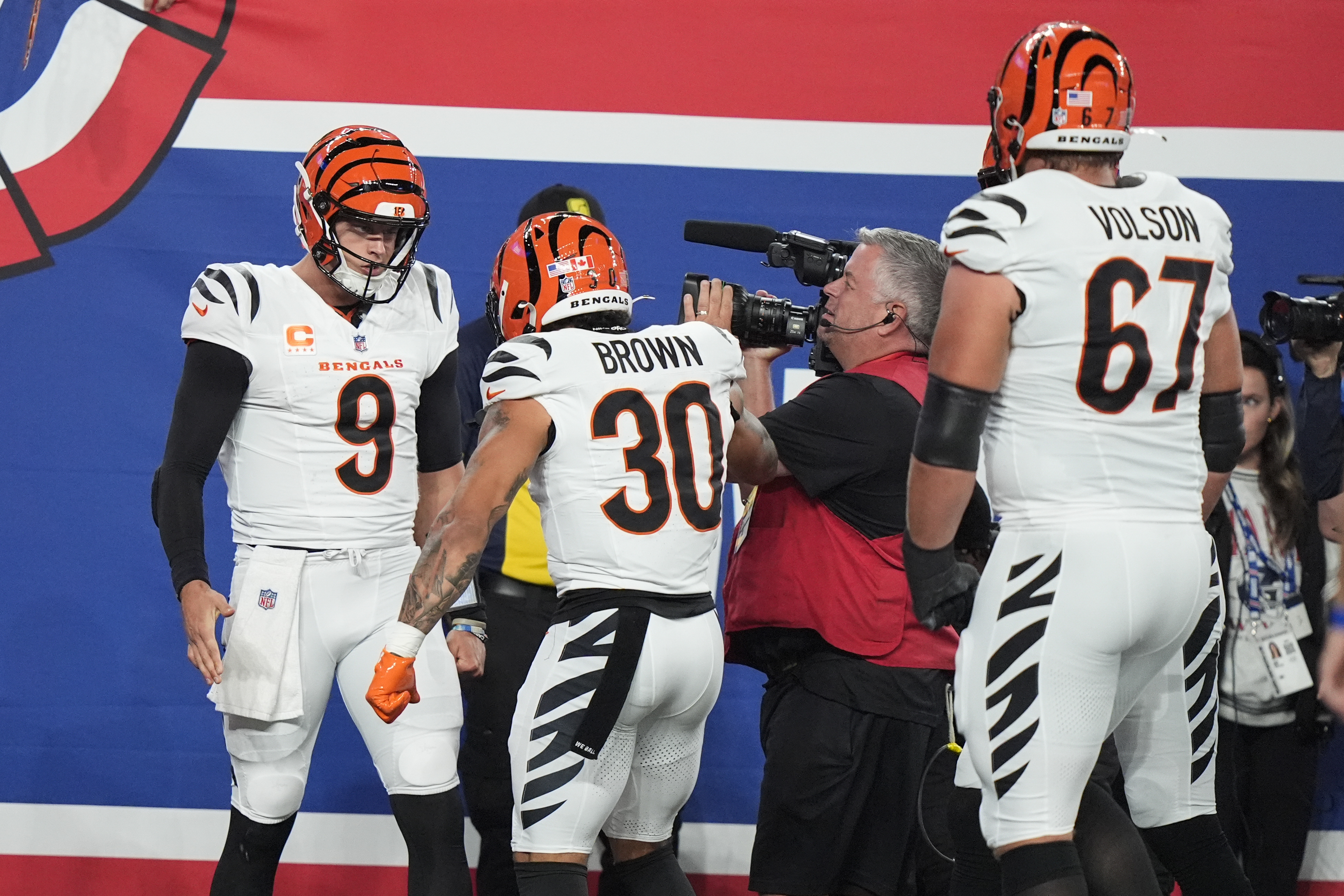 Cincinnati Bengals quarterback Joe Burrow (9) celebrates with running back Chase Brown (30) and guard Cordell Volson (67) after scoring a touchdown during the first half of an NFL football game against the New York Giants, Sunday, Oct. 13, 2024, in East Rutherford, N.J.