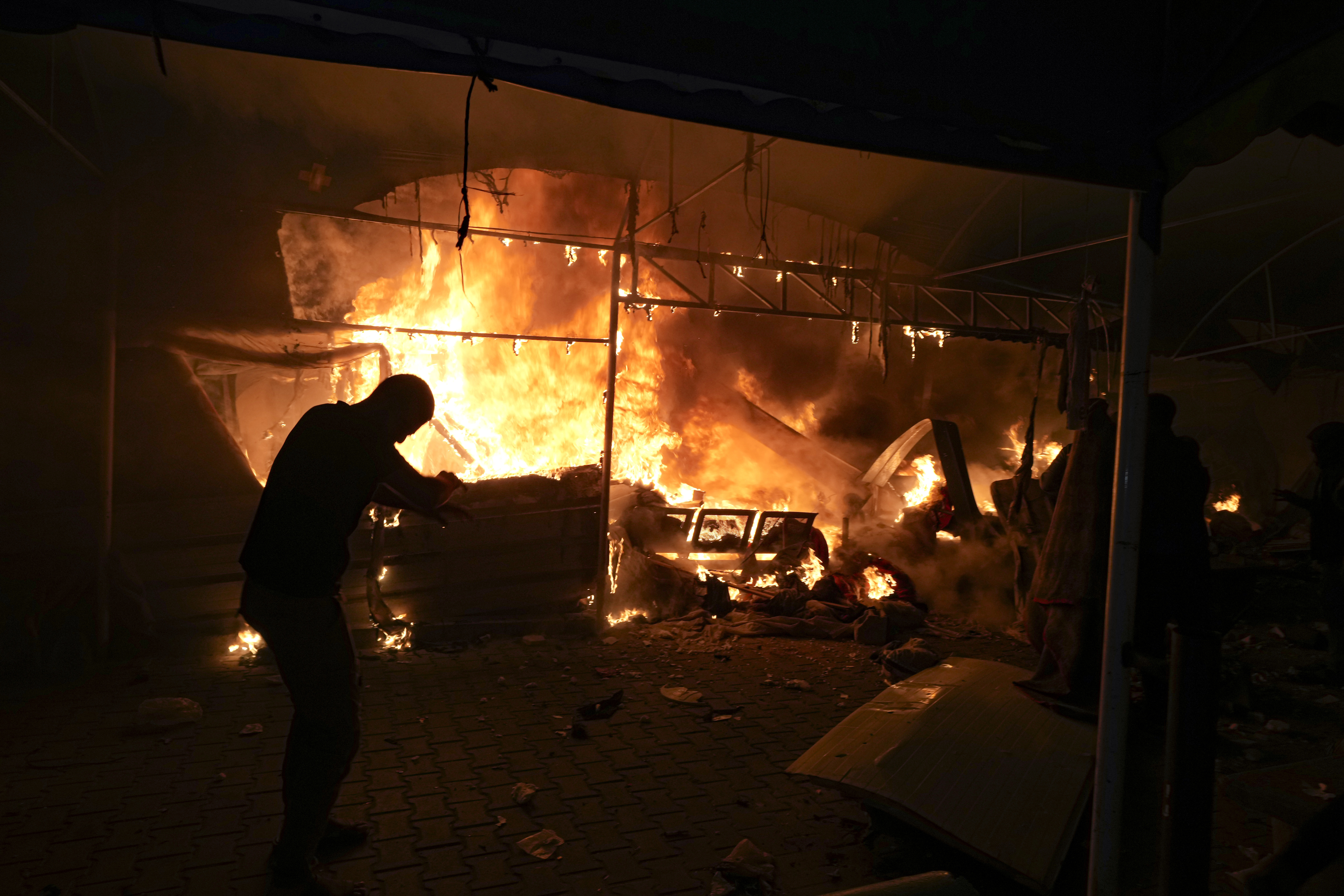 Palestinians react to a fire after an Israeli strike hit a tent area in the courtyard of Al Aqsa Martyrs hospital in Deir al Balah, Gaza Strip, Monday.