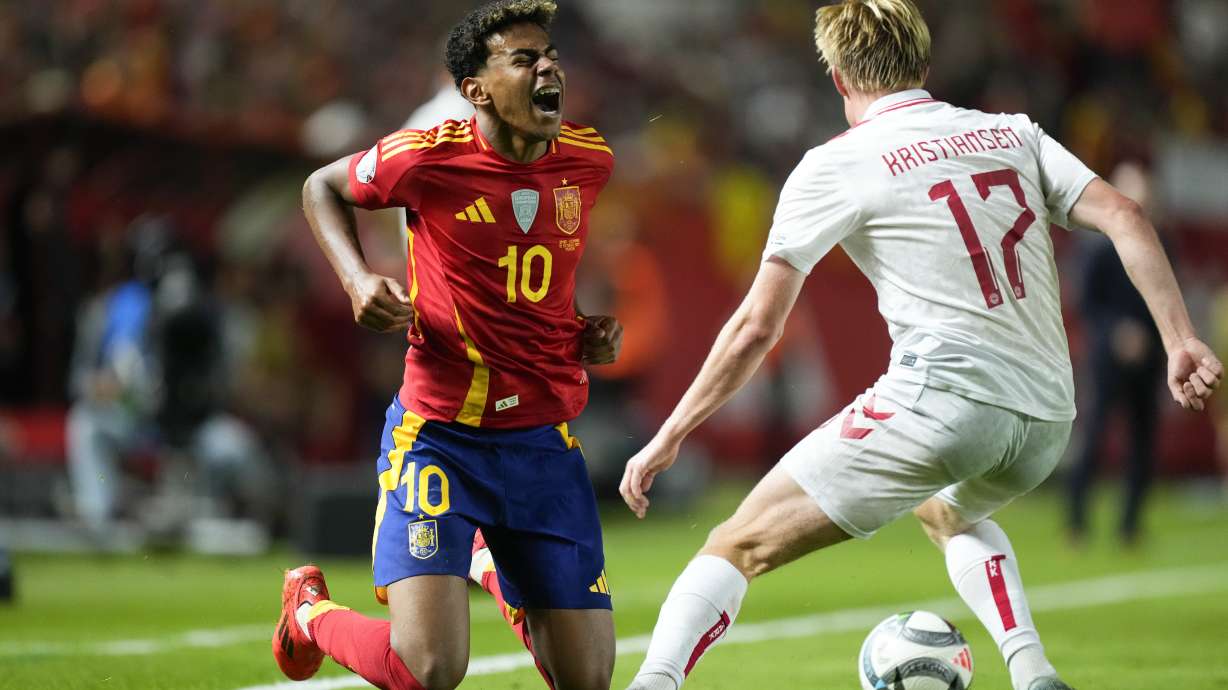 Spain's Lamine Yamal, left, and Denmark's Victor Kristiansen battle for the ball during the UEFA Nations League group 4 soccer match between Spain and Denmark in Murcia, Spain, Saturday, Oct. 12, 2024.