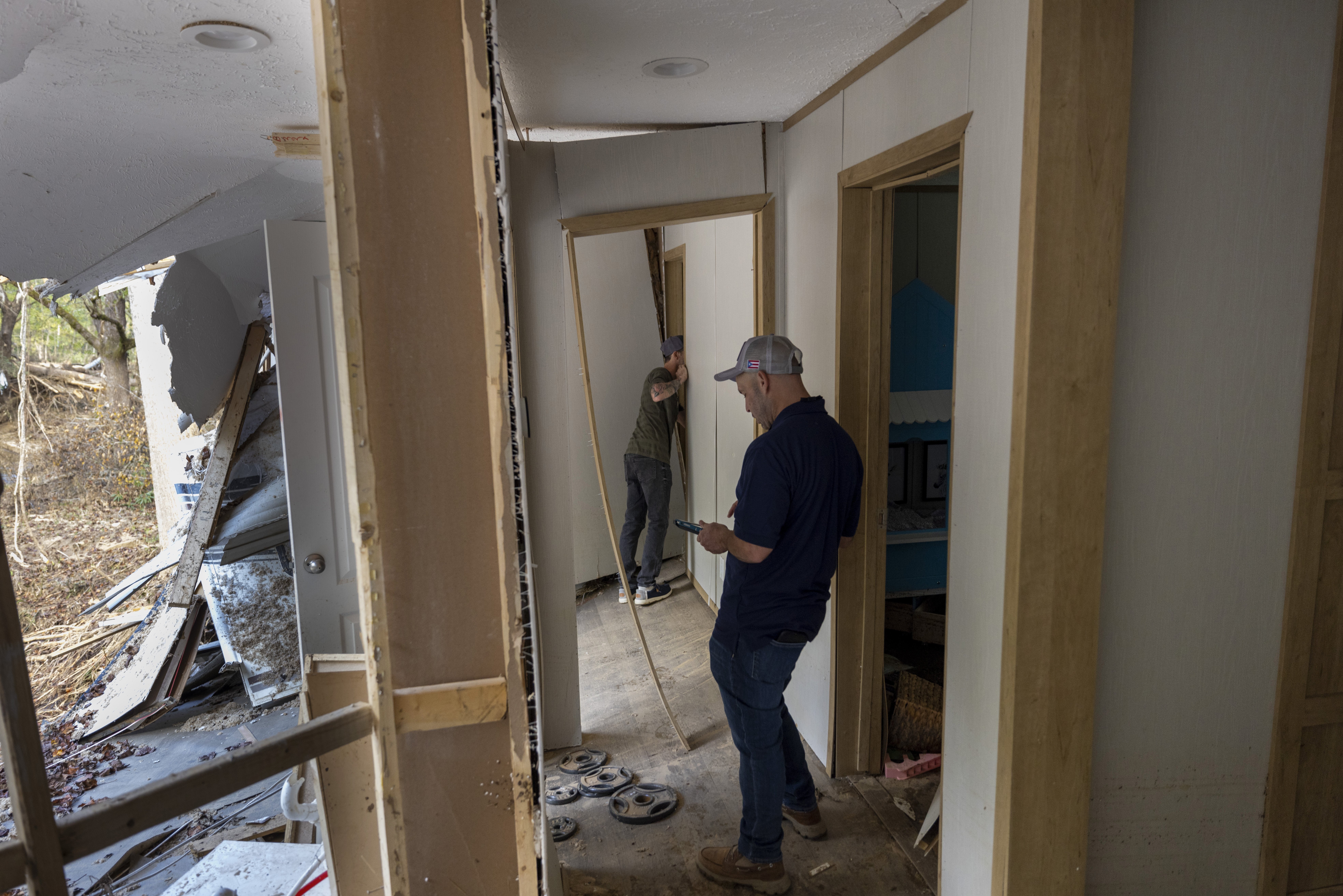 FEMA employee Jirau Alvaro works with Daniel Mancini on a report on the damage to his property on Oct. 6 near Black Mountain, N.C. Officials say federal disaster workers changed some of their hurricane-recovery efforts after threats.