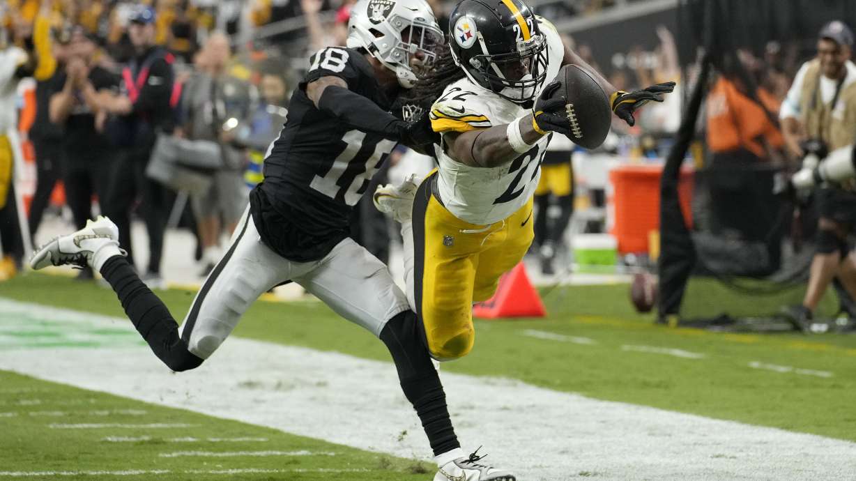 Pittsburgh Steelers running back Najee Harris, right, dives for the end zone to score past Las Vegas Raiders cornerback Jack Jones during the second half of an NFL football game in Las Vegas, Sunday, Oct. 13, 2024.