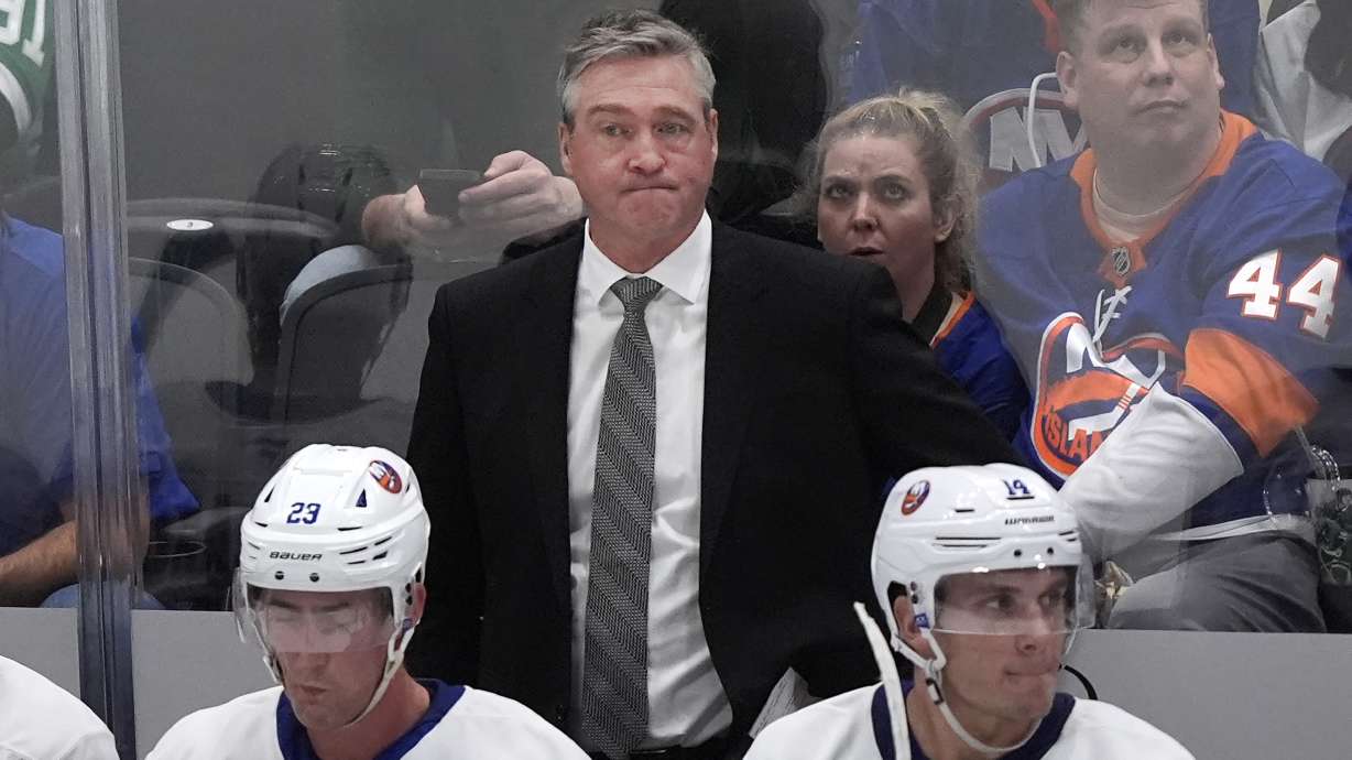 New York Islanders head coach Patrick Roy, center, looks on from behind centers Brock Nelson (29) and Bo Horvat (14) during the second period of an NHL hockey game against the Dallas Stars Saturday, Oct. 12, 2024, in Dallas.