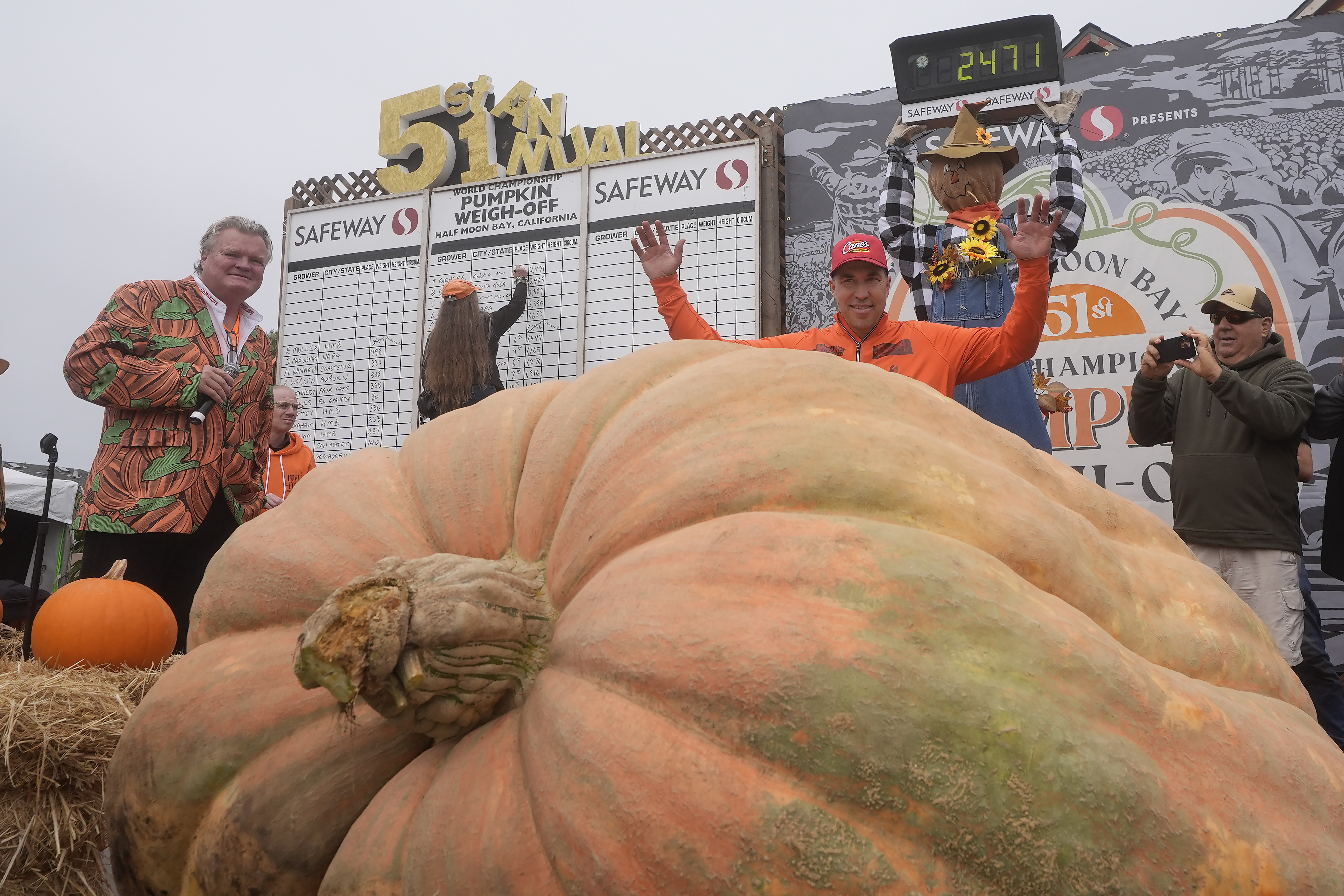 Travis Gienger, of Anoka, Minn., middle, celebrates after his pumpkin weighed in at 2,471 pounds to win at the Safeway World Championship Pumpkin Weigh-Off in Half Moon Bay, Calif., Monday.
