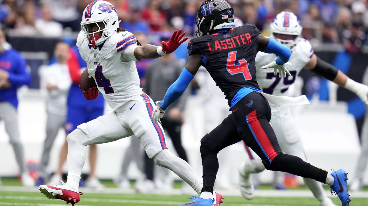 Buffalo Bills running back James Cook, left, runs from Houston Texans cornerback Kamari Lassiter during the first half of an NFL football game, Sunday, Oct. 6, 2024, in Houston.