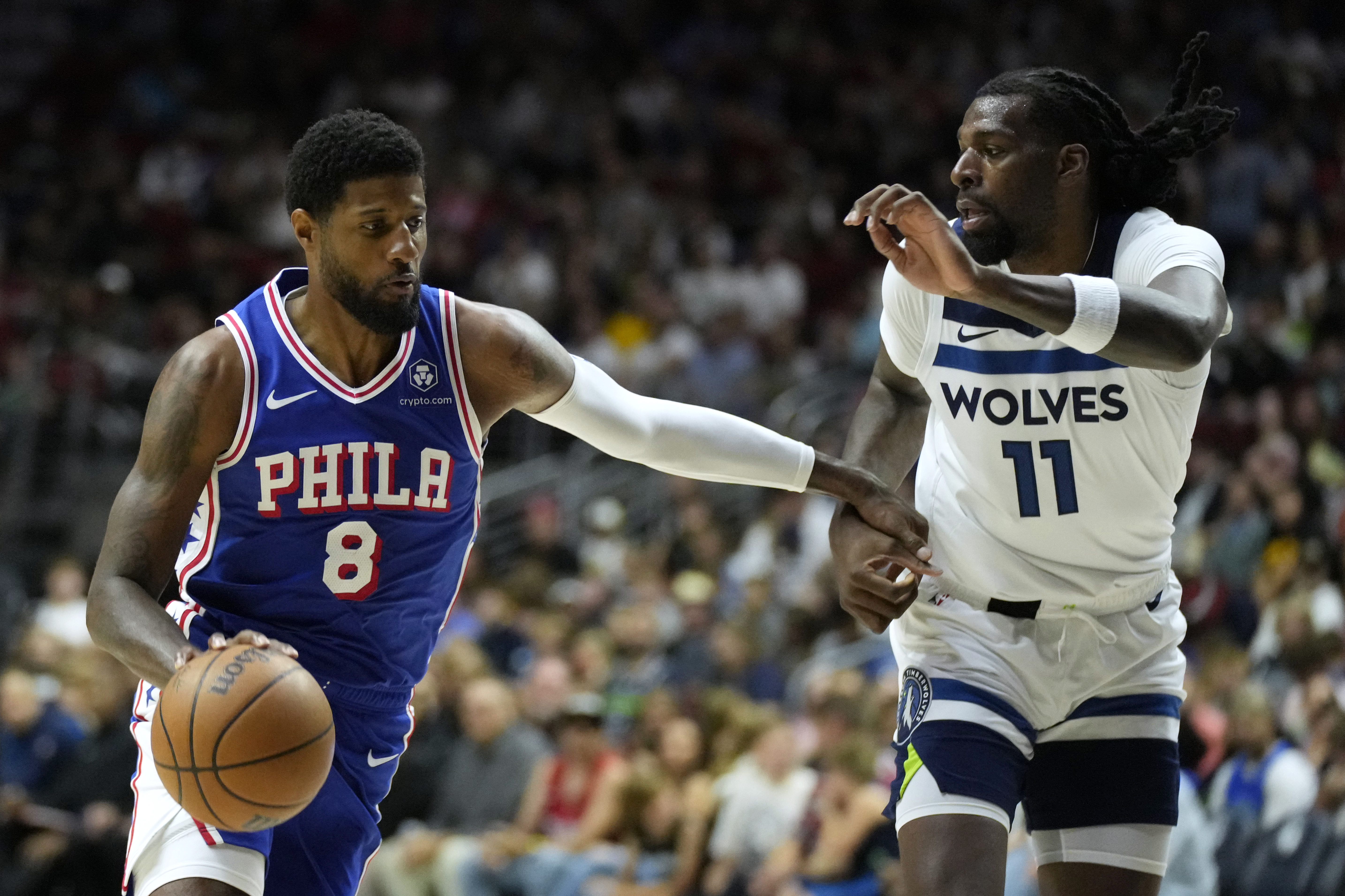 Philadelphia 76ers forward Paul George (8) drives to the basket past Minnesota Timberwolves center Naz Reid (11) during the first half of an NBA preseason basketball game, Friday, Oct. 11, 2024, in Des Moines, Iowa.