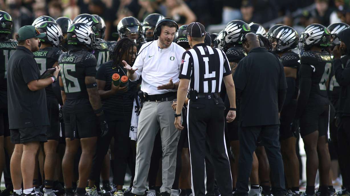 Oregon head coach Dan Lanning, center left, talks with a referee, center right, during an NCAA college football game against Ohio State, Saturday, Oct. 12, 2024, in Eugene, Ore.