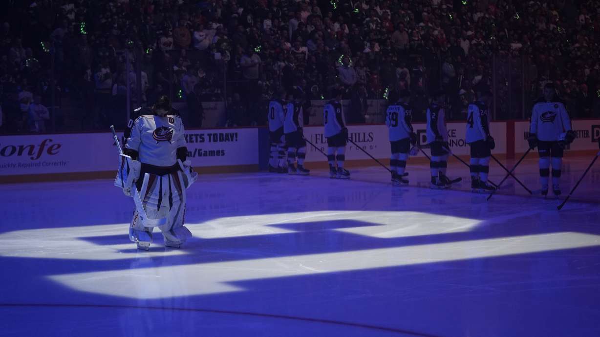 Columbus Blue Jackets goaltender Elvis Merzlikins (90) stands on a No. 13 on the ice honoring former Blue Jackets player Johnny Gaudreau and his brother Matthew Gaudreau who were killed by a driver in New Jersey in August, before an NHL hockey game against the Minnesota Wild, Thursday, Oct. 10, 2024, in St. Paul, Minn.