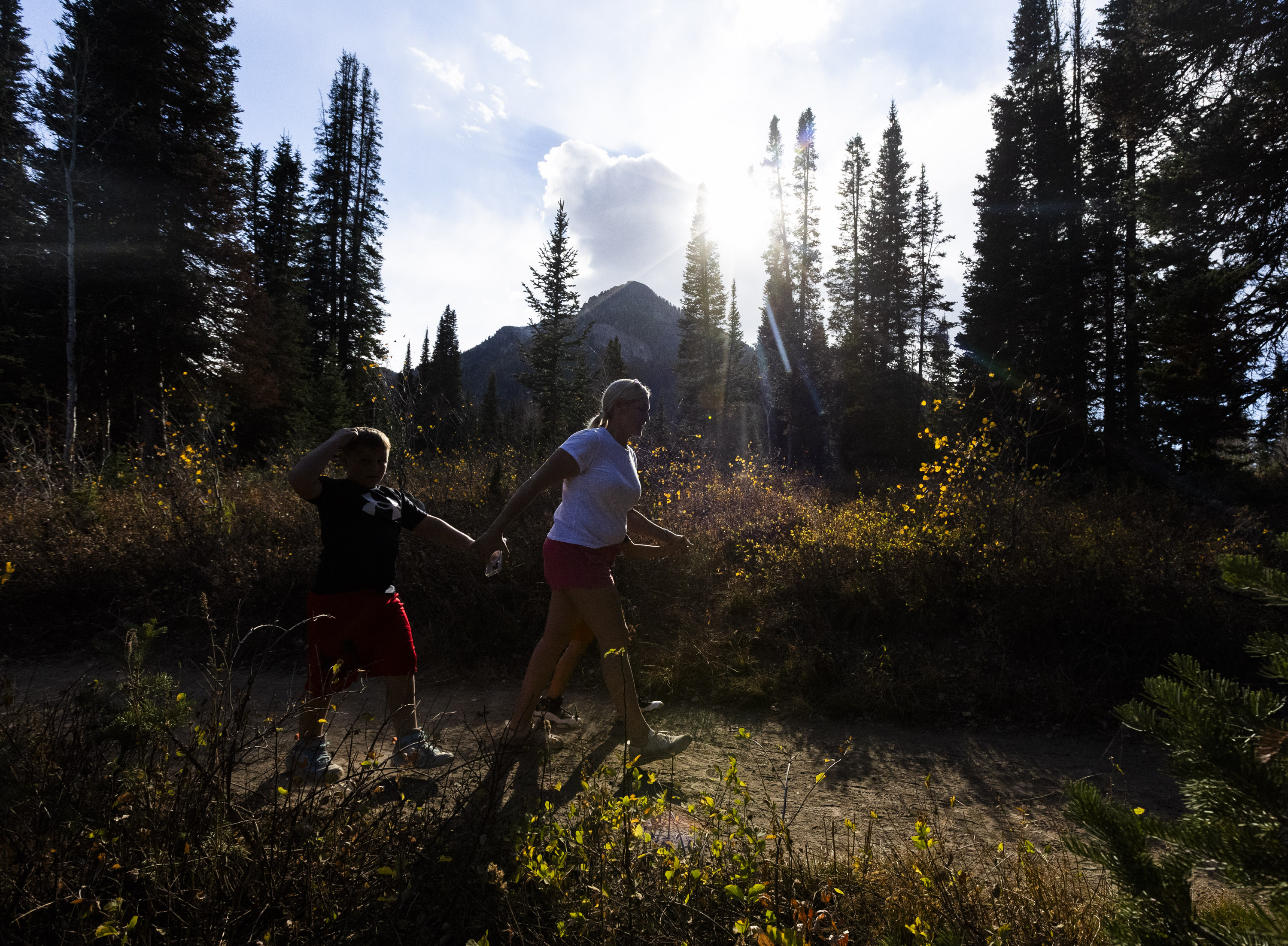 Tara Biggerstaff hikes with her sons Cooper, 7, on the left and Brady, 9, while the sun shines in Big Cottonwood Canyon on Monday. Utah's record-warm start to October will give way to a winter storm on Thursday. 